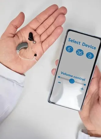 Audiologist showing smartphone app for adjusting hearing aid